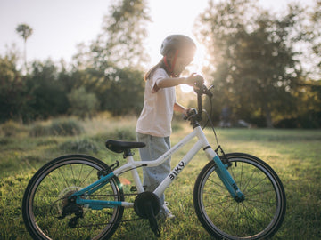 Child standing with a Biky geared kids’ bike 